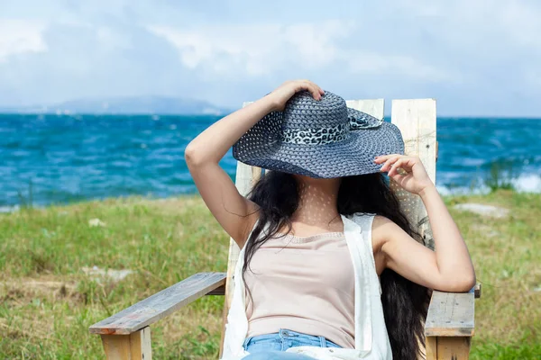 Genç Kadın Şapkası Deniz Bankında Oturuyor — Stok fotoğraf