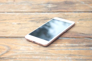 Ahşap masadaki akıllı telefon.