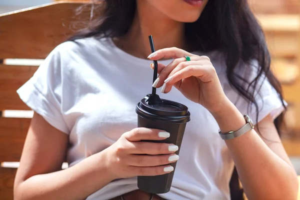 woman holding coffee in the street cafe