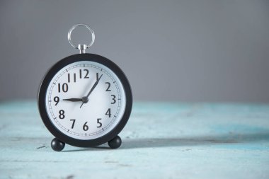 Mavi masadaki saat ve gri arkaplan