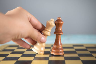 Kadın gri arka planda satranç oynuyor.