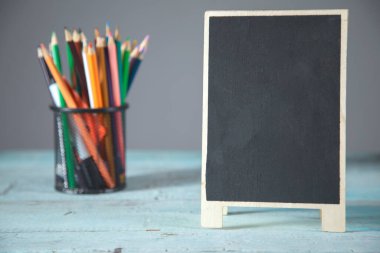 Masada kalemler olan saat ve karatahta.