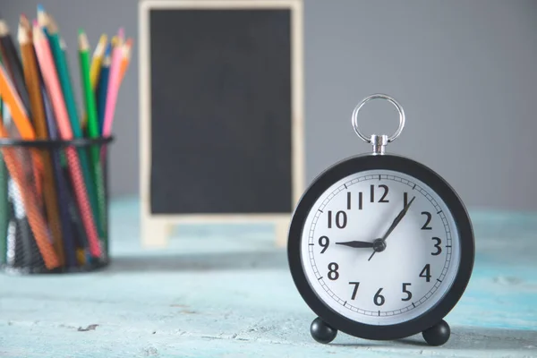 Orologio Lavagna Con Matite Sul Tavolo — Foto Stock