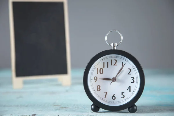 Lavagna Con Orologio Sul Tavolo Blu — Foto Stock