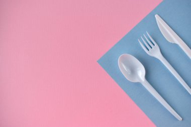 Sağ tarafta beyaz plastik çatal bıçak takımı var.