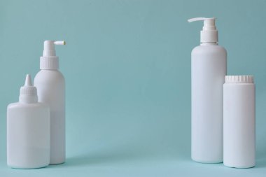 Bebek pudralı kavanoz, bir şişe talk pudrası, sıvı sabun ve mavi arka planda izole edilmiş duş jeli. Vücut bakımı. Spa Rahatlayın Bebek hijyeni.