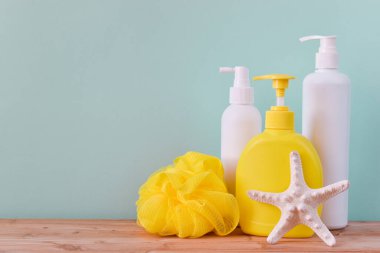 Kozmetik ürünleri için üç gemi, ahşap bir masanın arka planında nane renginde bir deniz yıldızı ve bezi. Çocuk bakımı. Çocuk hijyeni. Tuvaletlerde. Beyaz plastik şampuan şişeleri ya da duş jeli. Metin, tırnak içinde, özdeyişler için boş yer