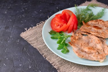 Tavuk ve sebze tabağı ahşap bir masada peçetenin üzerinde.