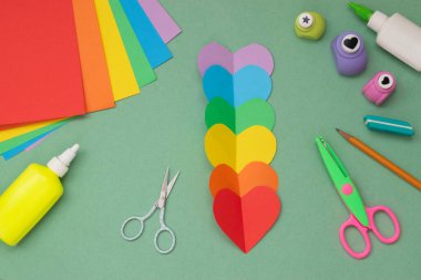 Renkli kağıt kalplerden altı tane kesilmiş. Kendiniz yapın. Sıralama. Renkli kağıttan tebrik kartı. El işi. Yukarıdan bak. LGBT. Gurur için ayağa kalk..