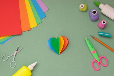 Gökkuşağı kalbini hazırla. Kendiniz yapın. Sıralama. Renkli kağıttan tebrik kartı. El işi. Yukarıdan bak. LGBT. Gurur için ayağa kalk..