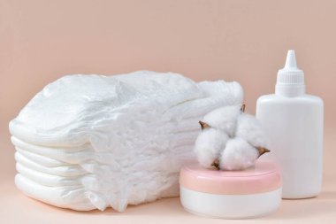 Beyaz bebek bezlerinin arka planında pudralı krem yumuşak, hafif bir arka planda.