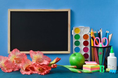 Okula dönelim. Mavi arka planda metin, kırtasiye ve çiçekler için yeri olan okul yönetim kurulu.