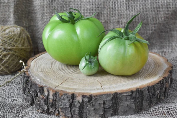 Drei Unreife Grüne Tomaten Liegen Auf Einem Holzständer — Stockfoto