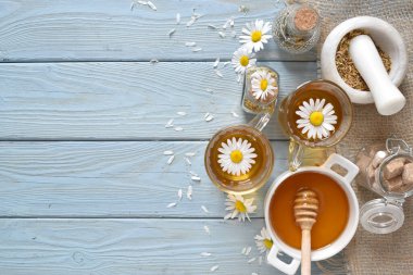 Papatya çayı şeffaf bir fincanda, ahşap bir masanın üstünde.