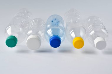 Beyaz arka planda beş plastik şişe uçar.