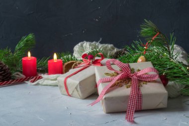 Yeni yıl aralığı. Noel kartı. Pankart. Yeşil dalların arka planında hediyelerle dolu bir kutu.