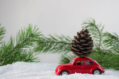 Karda çatıda şişlik olan kırmızı oyuncak araba. Kargo.