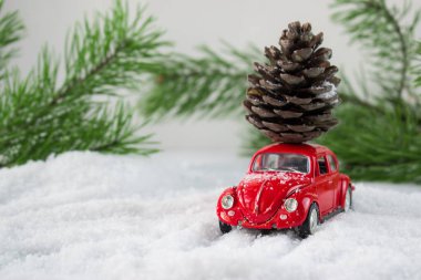 Karda çatıda şişlik olan kırmızı oyuncak araba. Kargo.