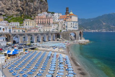 Geniş plaj Atrani köyü tarihi, Amalfi Coast, İtalya içinde beyaz mavi şemsiye ile kaplı.