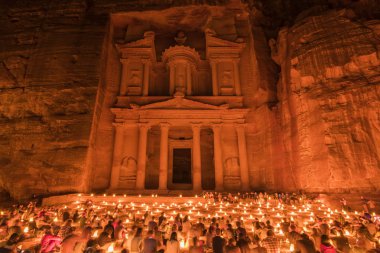Geceleri yerde oturan insanların büyük grup, rock Al Khazneh veya Hazine, Petra, Ürdün mimarisini kesti..