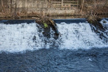 Nehirden gelen su bir buğday ve köpükle aşağı akar.