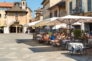 Orta San Giulio, Novara, Italy - August 28, 2018: People enjoying the outdoor bar in the historic center of ancient village of Orta San Giulio, located on the coast of Lake Orta in Piedmont, Italy clipart