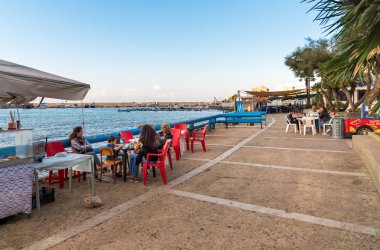 Sferracavallo, Sicilya, İtalya - 1 Ekim 2018: Waterfront promenade, Sferracavallo Köyü, Palermo, Sicilya ilinin öğleden sonra açık bar zevk insanlarla
