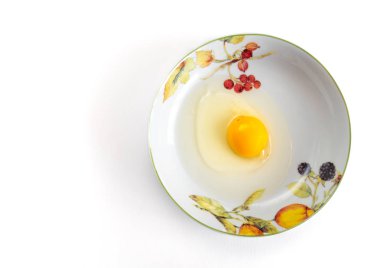 Beyaz arka plan üzerinde üstten görünüm izole tabak içinde çiğ yumurta sarısı.