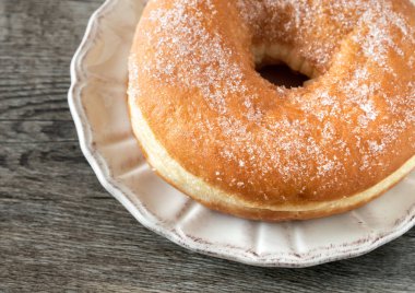 Tatlı çörek eski ahşap arka plan üzerinde plaka üzerinde şeker kaplı kızarmış.