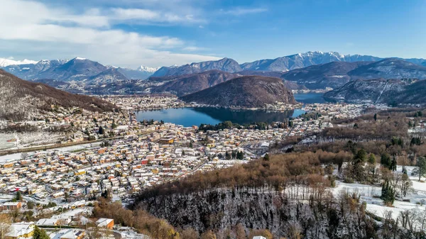 スイスアルプスと村カデリアーノ ヴィコナゴとイタリアのヴァレーゼ州のルガーノ湖の冬の風景の航空写真 — ストック写真