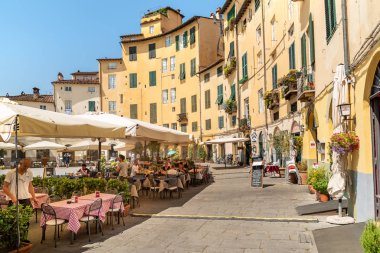 Lucca, Toskana, İtalya - 3 Temmuz 2019: Eski şehir Lucca, Toskana, İtalya'da restoranlar, barlar ve turistlerin yer verdiği amfitiyatro meydanı