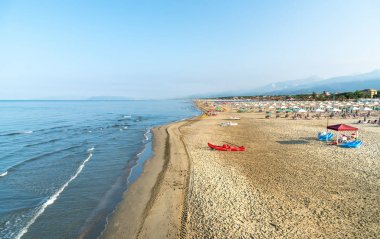 Versilia, Toskana, İtalya 'da sabahın erken saatlerinde Marina di Pietrasanta plajı beyaz kum, şemsiye ve sandalye manzarası
