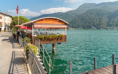 Morcote, Ticino, İsviçre - 26 Eylül 2019: Ticino, İsviçre'deki Lugano Gölü kıyısında açık hava barları ve hediyelik eşya dükkanları bulunan pitoresk Morcote köyünün manzarası