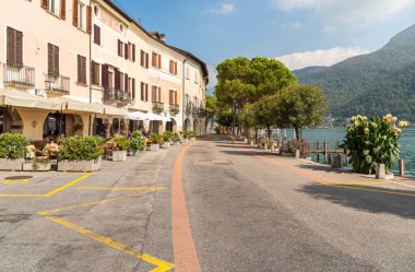 Morcote, Ticino, İsviçre - 26 Eylül 2019: Ticino, İsviçre'deki Lugano Gölü kıyısında açık hava barları ve hediyelik eşya dükkanları bulunan pitoresk Morcote köyünün manzarası