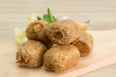 Tatlı ve ekşi sos ile kesme tahtası üzerinde kızarmış Yengeç hamur tatlısı. 