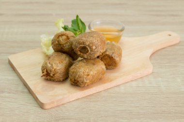 Tatlı ve ekşi sos ile kesme tahtası üzerinde kızarmış Yengeç hamur tatlısı. 