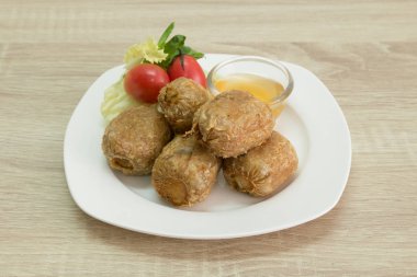 Tatlı ve ekşi soslu beyaz tabakta Fried Yengeç hamur tatlısı. 