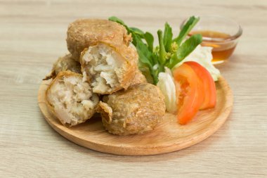 Tatlı ve ekşi sos ile ahşap plaka üzerinde kızarmış Yengeç hamur tatlısı. 