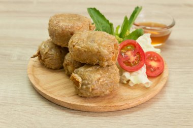 Tatlı ve ekşi sos ile ahşap plaka üzerinde kızarmış Yengeç hamur tatlısı. 