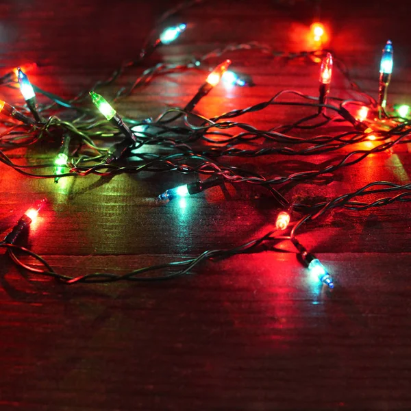 木製の背景のライトとクリスマスの花輪 ストック画像