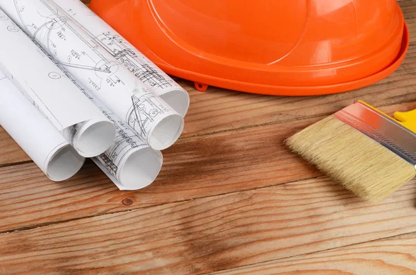 Construction helmet and brush on a wooden background