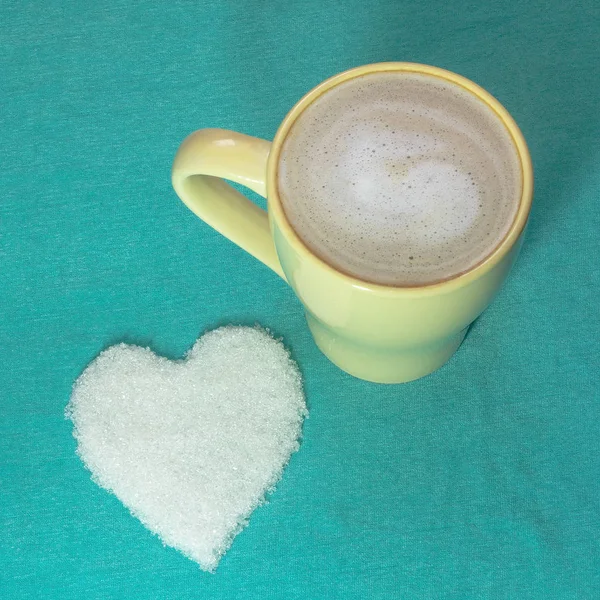 Turkuaz backgr kar-beyaz şeker kalp ile latte kahve