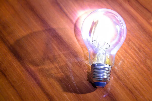 Lámpara de edison decorativa retro brillante sobre una superficie de madera . — Foto de Stock