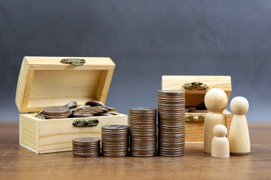Birçok madeni para para biriktirmek ve finansal planlama sigortası için aile içi tahta bebeklerle bir grafik şeklinde istiflenir..