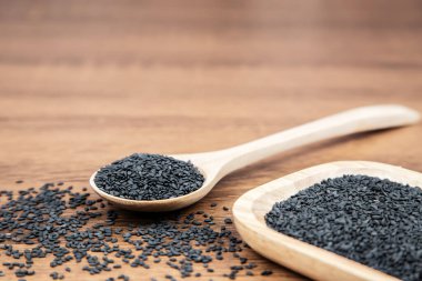 Sağlıklı yemek ve diyet kavramları için tahta kaşıkta siyah susam tohumları..