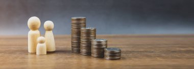 Birçok madeni para para biriktirmek ve finansal planlama sigortası için aile içi tahta bebeklerle bir grafik şeklinde istiflenir..