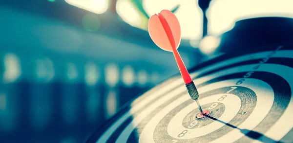 Hedef tahtası ya da dart tahtası dart okuyla hedeflenen hedeflerin merkezini vurur iş hedefleri ve kazanma hedefleri iş kavramları.
