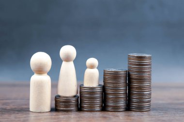 Birçok madeni para para biriktirmek ve finansal planlama sigortası için aile içi tahta bebeklerle bir grafik şeklinde istiflenir..