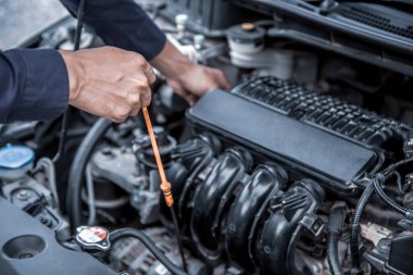 Otomatik tamirci motor yağı seviyesini araba motor yağı değişimine kontrol ediyor 