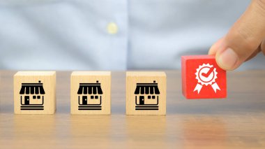 Küçük işletme büyümesi ve finansal pazarlama planlamasının genişleme stratejisi için bayilik mağaza simgeleriyle dolu küp tahta bloklarda el yapımı kalite sembolü seç.